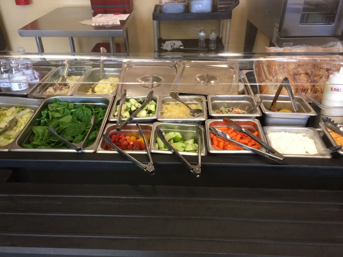 Salad bar line stocked with fresh vegetables